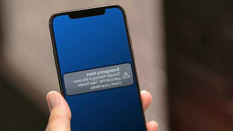 Mobile phone displaying emergency alert for tornado warning.